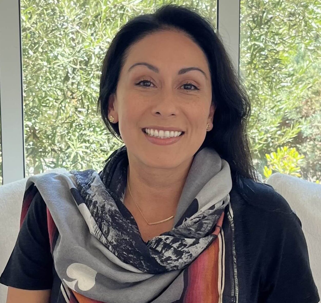 Photo of Yvette Rios smiling in front of a window.