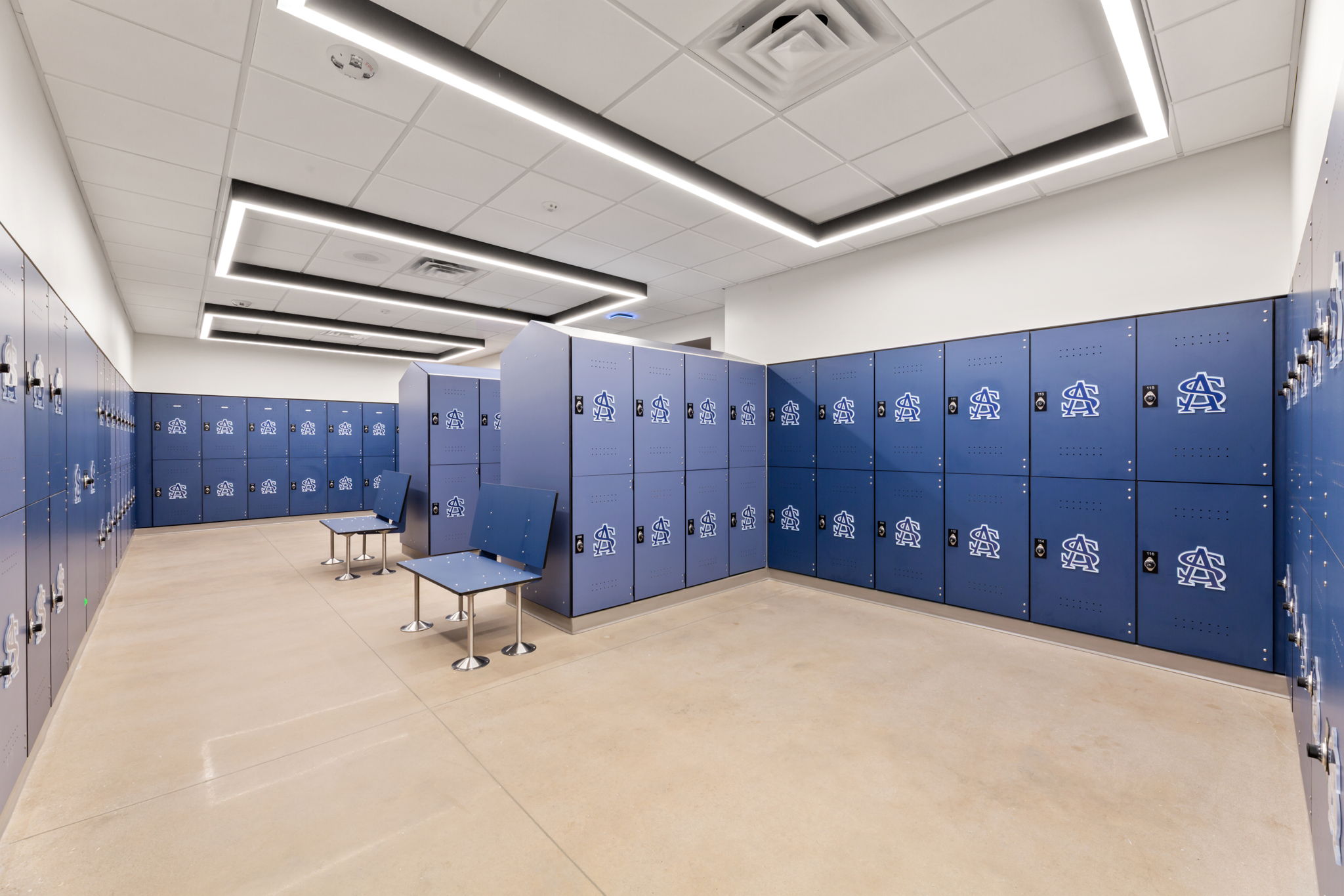 Photo of girls' locker room. Blue lockers with SAs logos line the room.