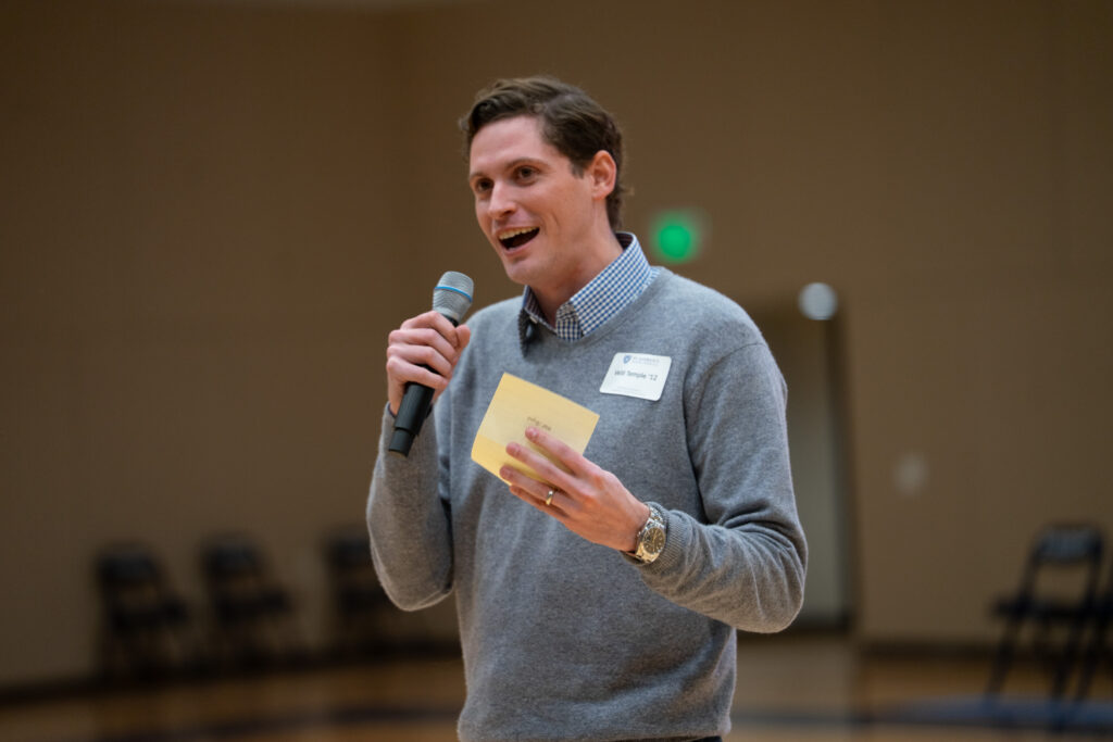 SAS Alum Will Temple smiles while speaking into a microphone.