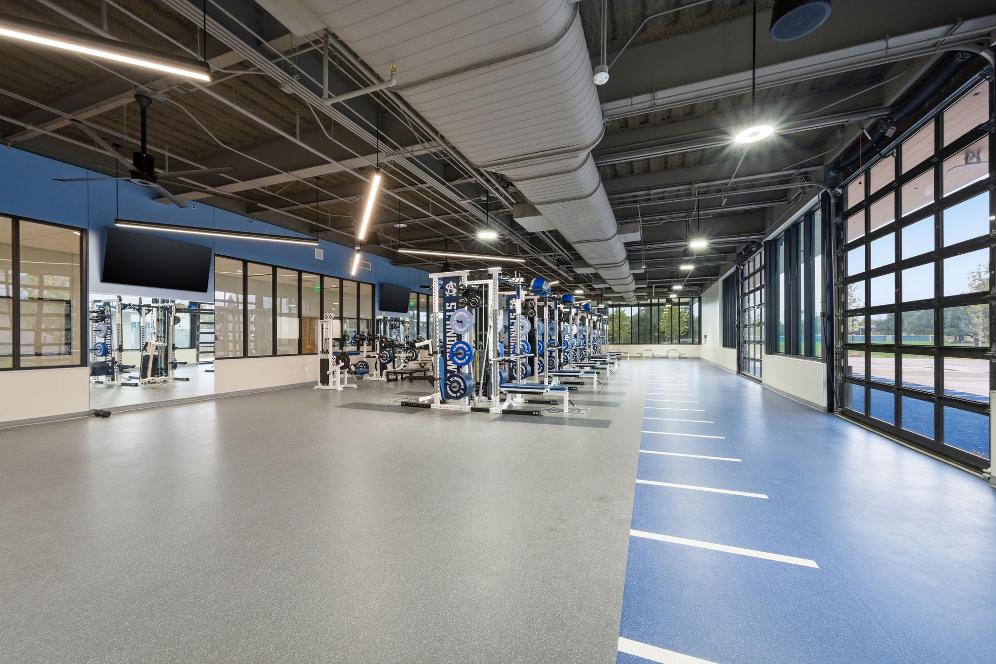 Photo of sports performance center with weight sets in the center of the room.