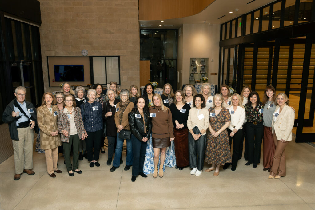 Full group photo of past PA residents standing in Highlander Hall lobby.