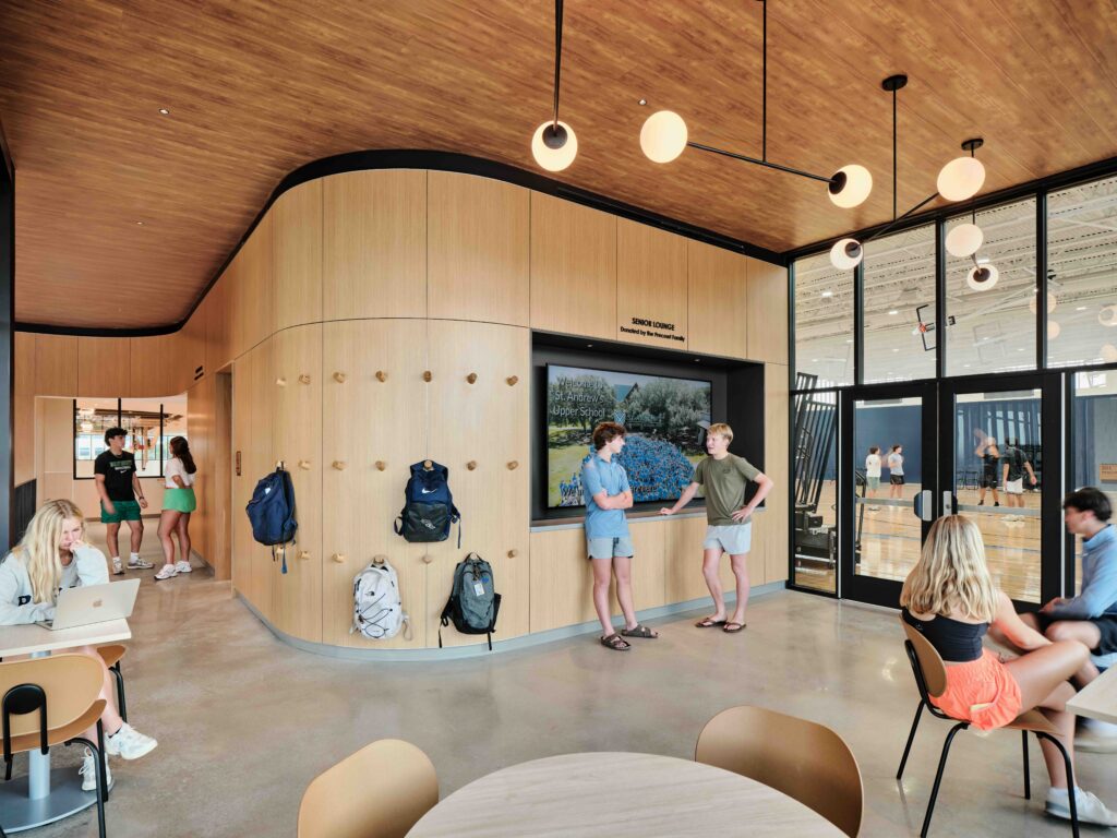 Students sit and stand throughout the bright senior lounge.