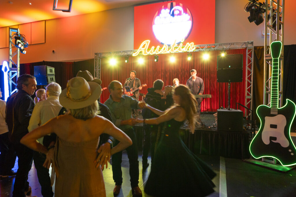 People dance and crowd around Bob Schneider's band.