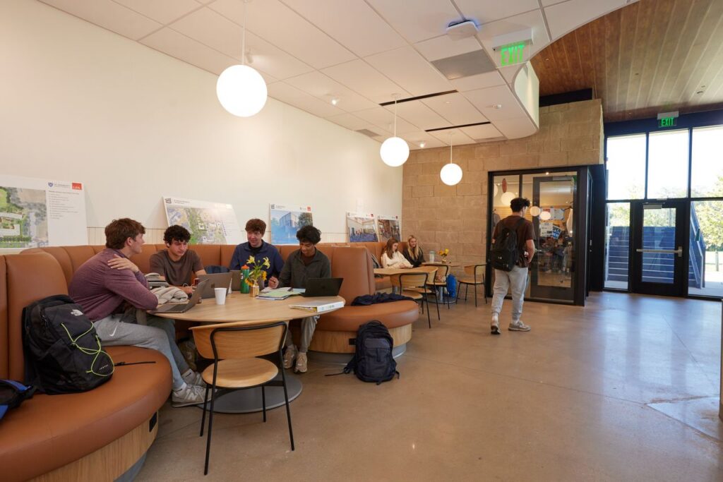 Students sit in booths and study in a brightly lit room.
